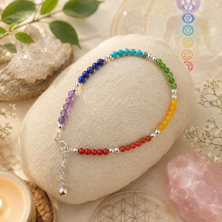 Colorful beaded Chakra bracelet on a stone with crystals and leaves in the background