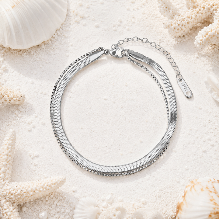 Double chain silver anklet on a beach inspired background.