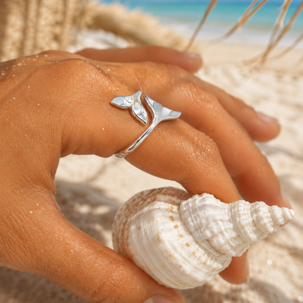 girls hand on beach wearing silver whale tail ring 